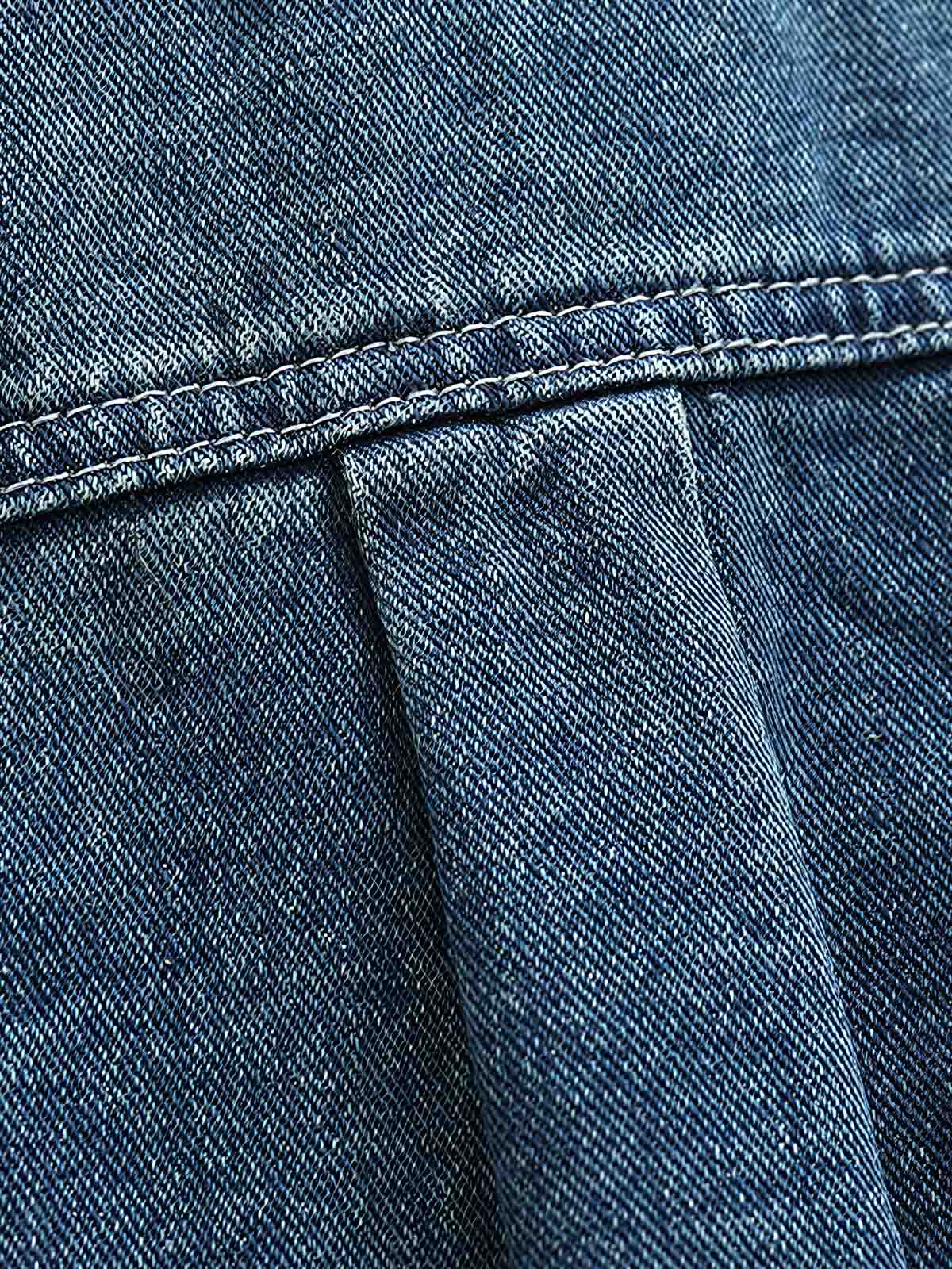 シャツのダブルポケットと金属ボタンのディテール画像。