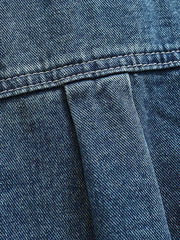 シャツのダブルポケットと金属ボタンのディテール画像。