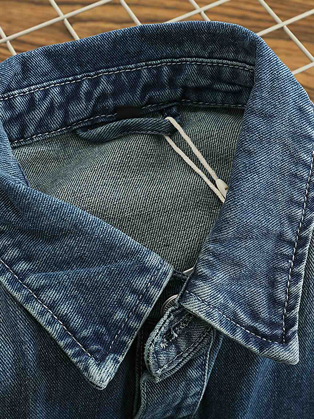 シャツのダブルポケットと金属ボタンのディテール画像。