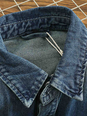 シャツのダブルポケットと金属ボタンのディテール画像。