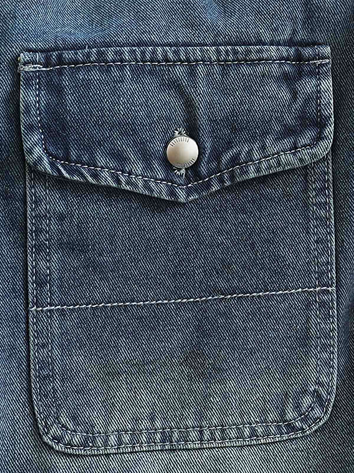 シャツのダブルポケットと金属ボタンのディテール画像。