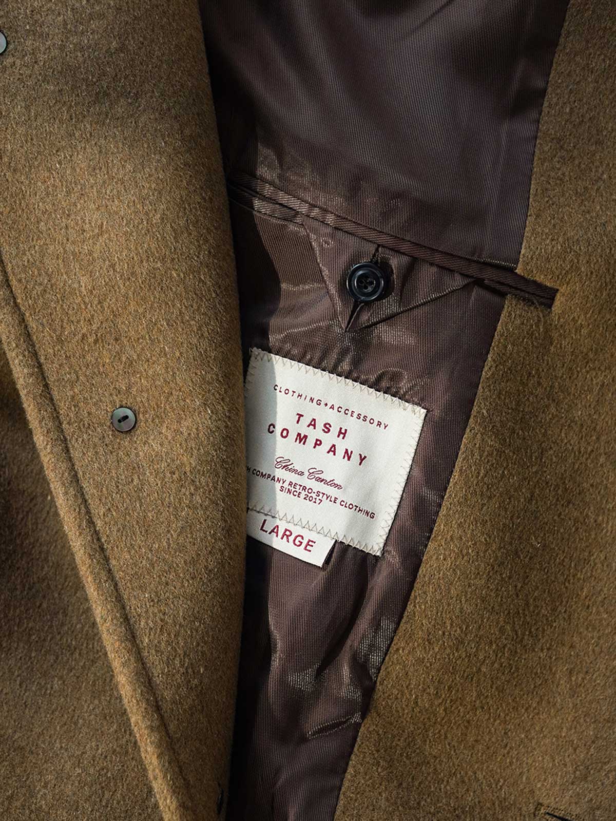 詳細画像: ウール生地のヘリンボーンディテールとウエストベルトデザインの特写