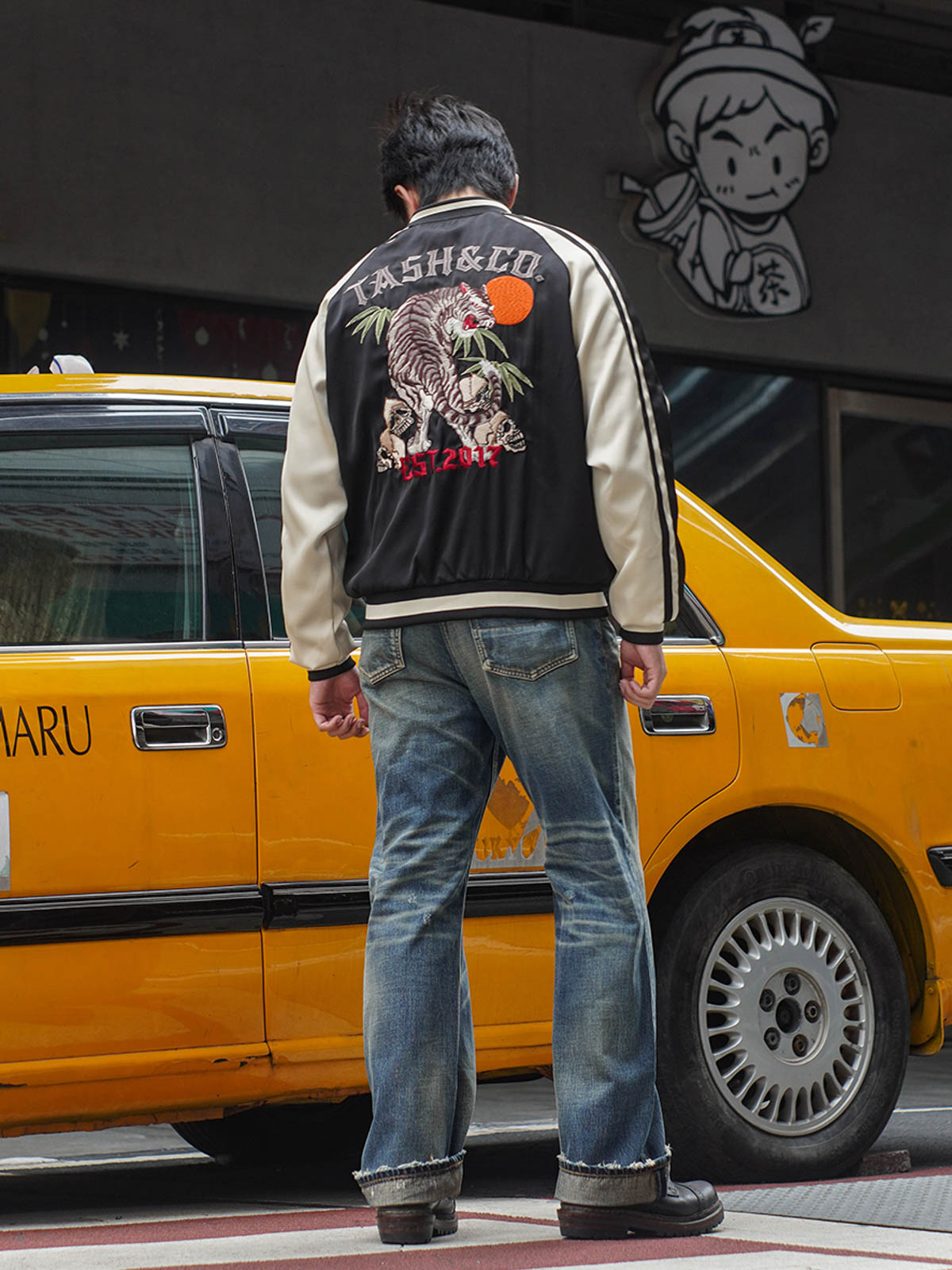 モデルが虎刺繍スカジャンを着用し、その文化的な意味とビンテージスタイルを披露