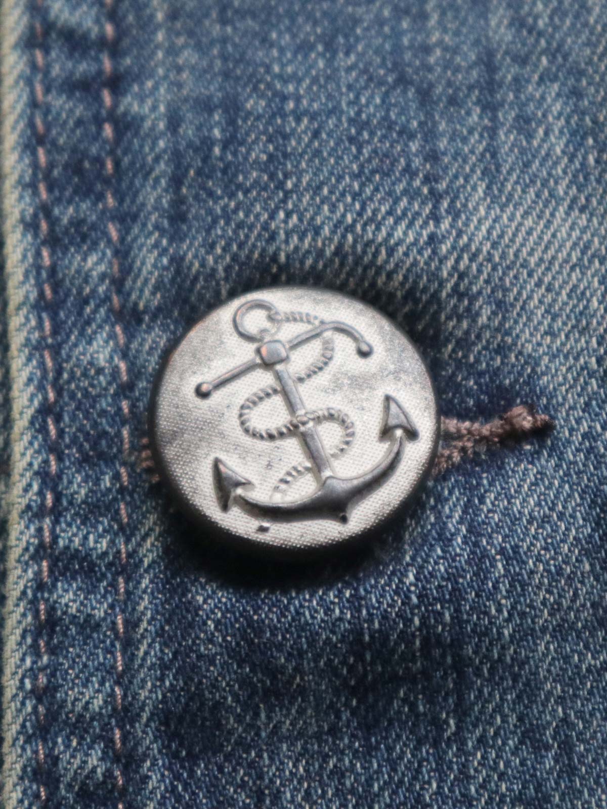 トレンチコートのディテールショット、大きな襟、ダブルブレスト、セルビッチデニムを展示