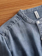 製品画像: ヴィンテージスタンドカラーデニムシャツの正面展示
詳細画像: スタンドカラーとウォッシュドデニムのディテール展示