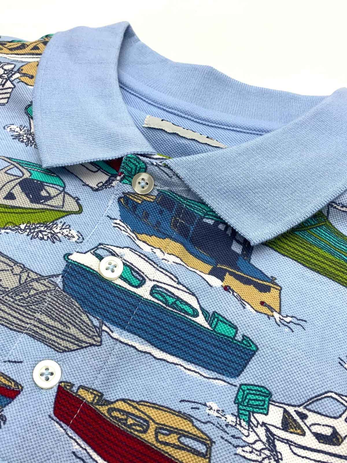 製品画像: ナポリ観光船をモチーフにしたカラフルなプリントが特徴のコットンポロシャツの正面全体画像。
詳細画像: カラフルな観光船プリントと、裾のサイドスリット部分のディテールクローズアップ。