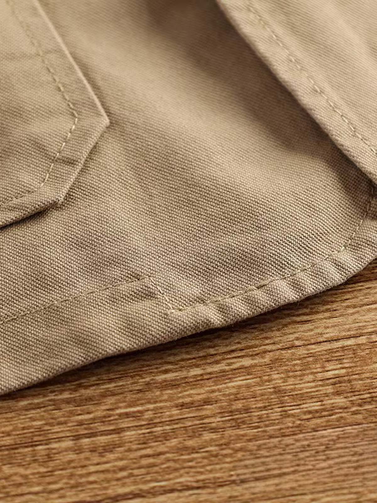 製品画像: ヴィンテージサイクリングベストの正面全体画像。
詳細画像: 多機能ポケットとVネックのヴィンテージボタンディテールのクローズアップ。