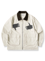 製品画像: アイボリーのハンドグラフィックルーズフィットジャケットの全体画像。ジャケットの全体的なシルエットとデザインが強調されています。
詳細画像: ハンドグラフィックのディテール画像。プリントの細部と質感が際立っています。