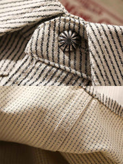 製品画像: アイボリー色のスナップボタン付きストライプシャツの正面図。ヴィンテージウエスタンデザインが特徴。
詳細画像: シャツの肩部ディテールとトライアングルレザー補強部分のクローズアップ。ダブルステッチと色織り生地が耐久性とスタイルを強調。