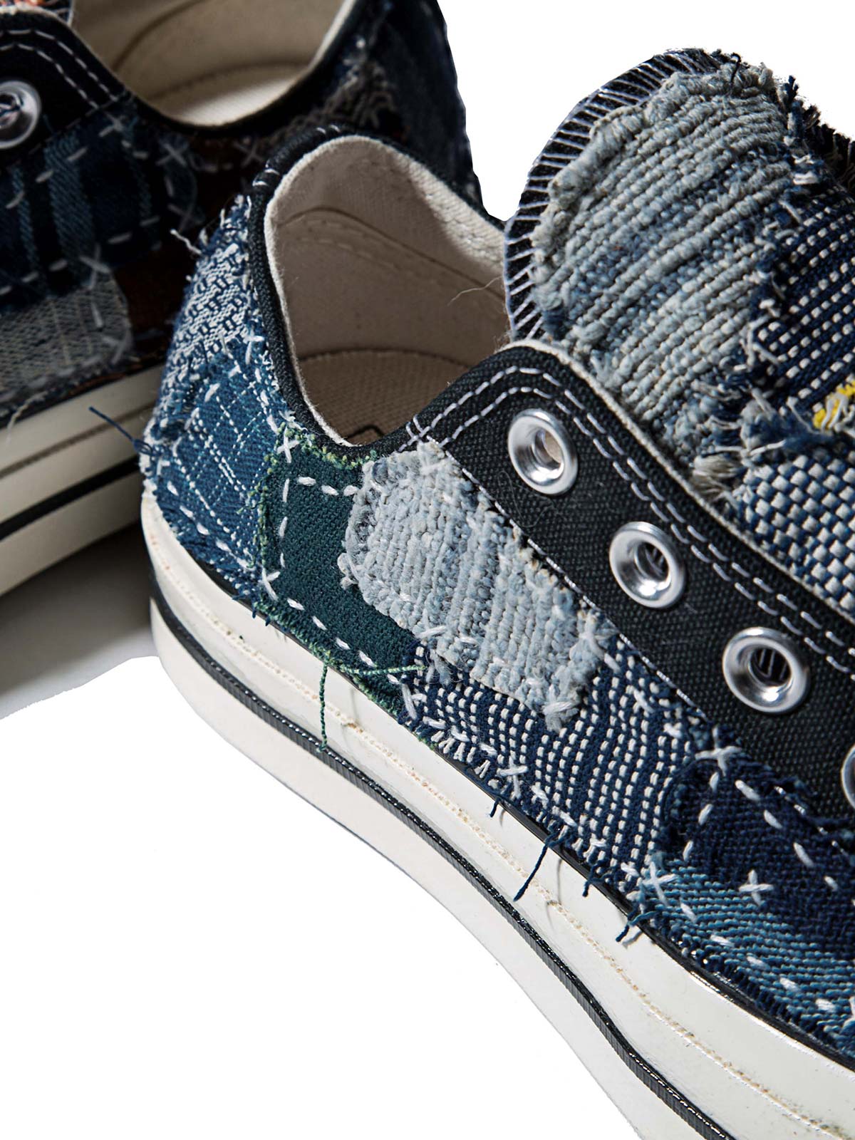 製品画像: 植物染め古布手作り刺し子パッチワーク1970Sローカットキャンバスシューズの正面画像。手工芸とヴィンテージデザインの融合が特徴的。
詳細画像: 刺し子と侗族(ドン族)の手織り布のディテール特写。伝統技術の細部が見える画像。