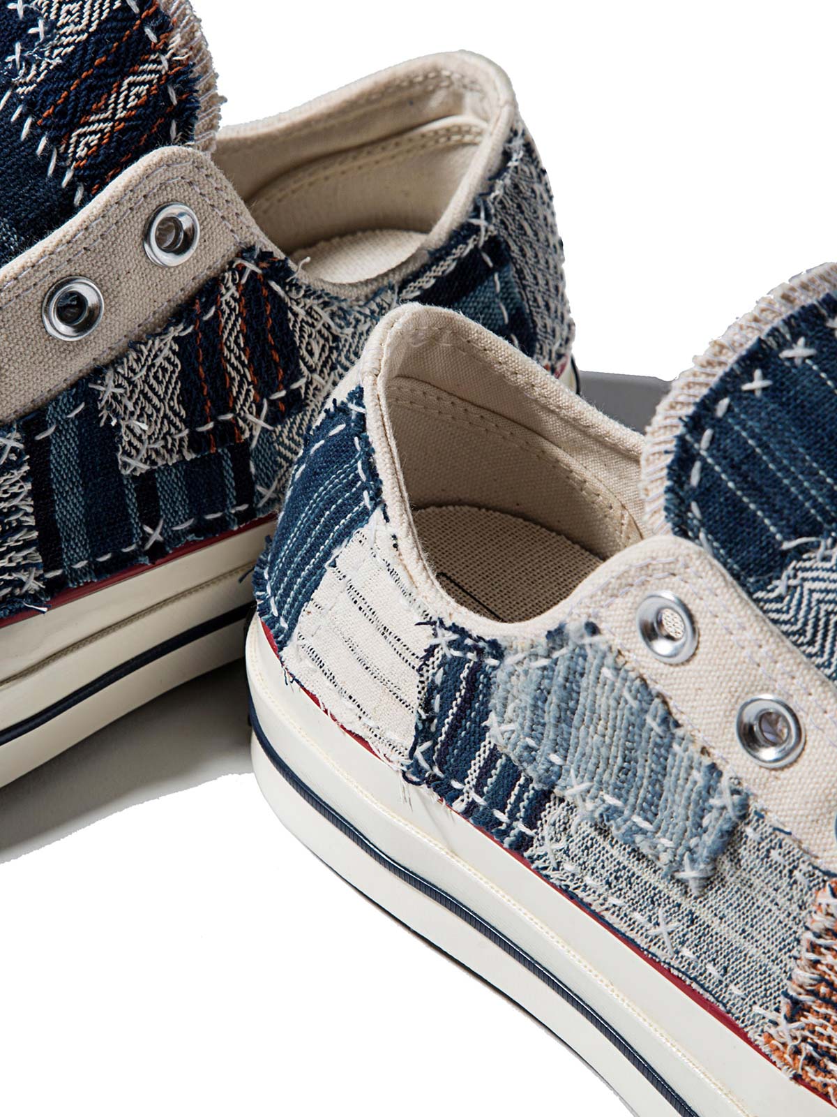 製品画像: 植物染め古布手作り刺し子パッチワーク1970Sローカットキャンバスシューズの正面画像。手工芸とヴィンテージデザインの融合が特徴的。
詳細画像: 刺し子と侗族(ドン族)の手織り布のディテール特写。伝統技術の細部が見える画像。