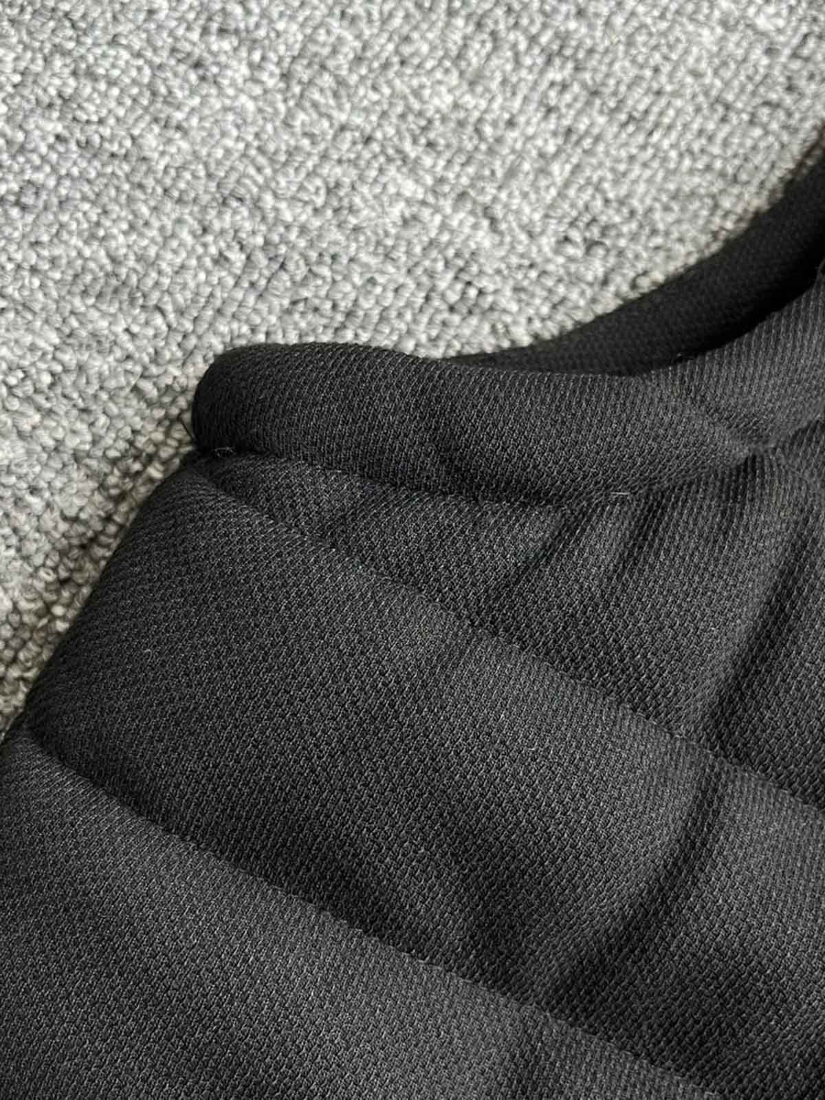 製品画像: 中綿入りの無地スタンドカラーのベスト正面ビュー。シンプルでスタイリッシュなデザインと、中綿素材の保温効果が際立つ。
詳細画像: 中綿入りベストのスタンドカラーと中綿素材のディテール。冬の寒さから守るための中綿素材とスタンドカラーの特徴が明確に見える。