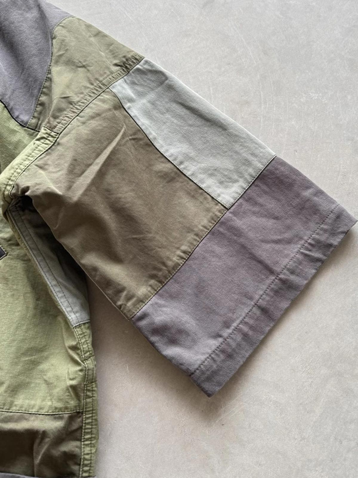 製品画像: ヴィンテージウォッシュ加工のパッチワーク生地を使用した五分袖ハンテンの正面画像。色のコントラストデザインとヴィンテージスタイルが鮮明に表示され、レトロな風合いが強調されています。
詳細画像: YKK真鍮ジッパーと真皮ディテールのクローズアップ。重工水洗加工による独自のビンテージ感が詳しく見える特写画像。