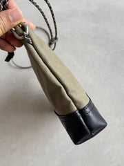 製品画像: 頭層牛革とウォッシュキャンバスのショルダーバッグ、正面から見た全体像。レトロなデザインと高品質な素材が際立つ。
詳細画像: 頭層牛革のショルダーバッグの金属ハードウェアと純銅YKKファスナーの詳細特写。本革引き手の質感と精密な仕上げが強調されている。