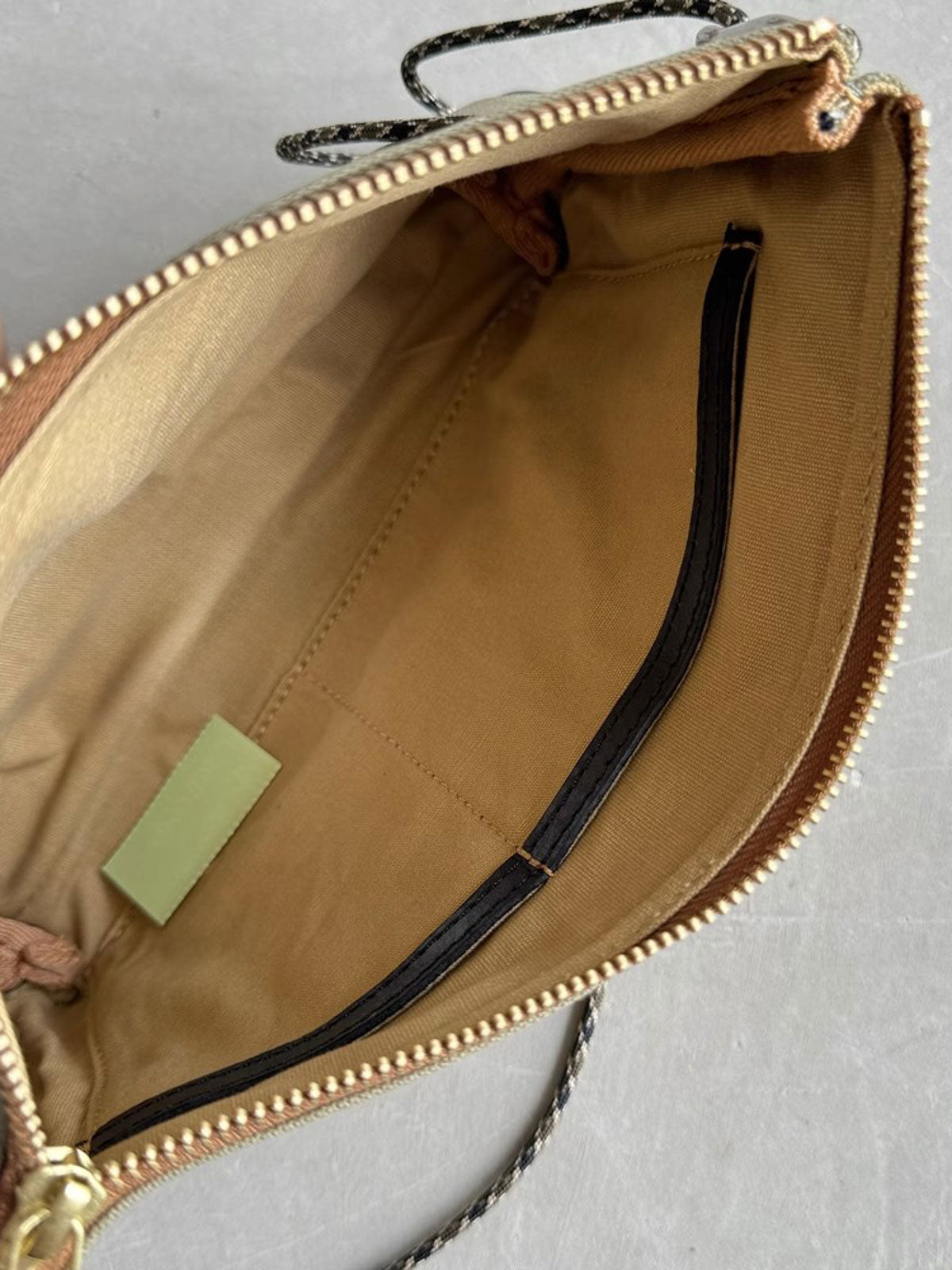 製品画像: 頭層牛革とウォッシュキャンバスのショルダーバッグ、正面から見た全体像。レトロなデザインと高品質な素材が際立つ。
詳細画像: 頭層牛革のショルダーバッグの金属ハードウェアと純銅YKKファスナーの詳細特写。本革引き手の質感と精密な仕上げが強調されている。