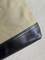 製品画像: 頭層牛革とウォッシュキャンバスのショルダーバッグ、正面から見た全体像。レトロなデザインと高品質な素材が際立つ。
詳細画像: 頭層牛革のショルダーバッグの金属ハードウェアと純銅YKKファスナーの詳細特写。本革引き手の質感と精密な仕上げが強調されている。