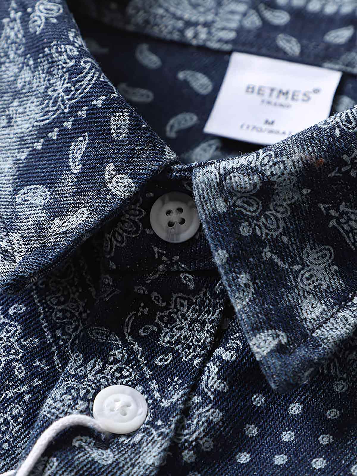 詳細画像: ペイズリー柄のプリントとボタンのディテール、デニム素材の質感を強調
