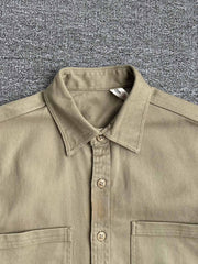 製品画像: クラシックなツイル生地の長袖ワークシャツの正面画像。100%コットン素材で作られた耐久性のあるシャツで、レトロなワークユニフォームスタイルを再現。
詳細画像: 高品質なツイル生地の長袖ワークシャツのディテール画像。細やかな縫製とコットンツイル素材の耐摩耗性が強調された画像。クラシックなワークスタイルの要素が確認できるクローズアップショット。