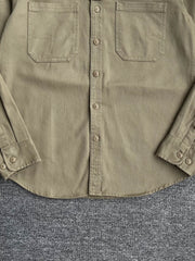 製品画像: クラシックなツイル生地の長袖ワークシャツの正面画像。100%コットン素材で作られた耐久性のあるシャツで、レトロなワークユニフォームスタイルを再現。
詳細画像: 高品質なツイル生地の長袖ワークシャツのディテール画像。細やかな縫製とコットンツイル素材の耐摩耗性が強調された画像。クラシックなワークスタイルの要素が確認できるクローズアップショット。