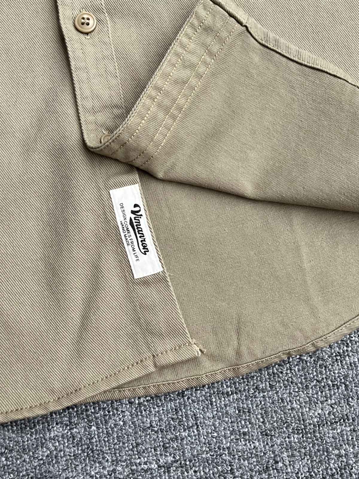 製品画像: クラシックなツイル生地の長袖ワークシャツの正面画像。100%コットン素材で作られた耐久性のあるシャツで、レトロなワークユニフォームスタイルを再現。
詳細画像: 高品質なツイル生地の長袖ワークシャツのディテール画像。細やかな縫製とコットンツイル素材の耐摩耗性が強調された画像。クラシックなワークスタイルの要素が確認できるクローズアップショット。