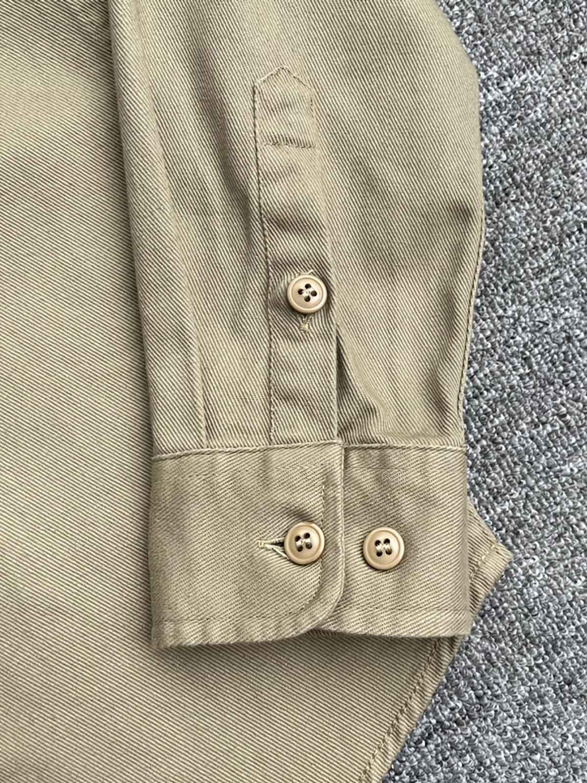 製品画像: クラシックなツイル生地の長袖ワークシャツの正面画像。100%コットン素材で作られた耐久性のあるシャツで、レトロなワークユニフォームスタイルを再現。
詳細画像: 高品質なツイル生地の長袖ワークシャツのディテール画像。細やかな縫製とコットンツイル素材の耐摩耗性が強調された画像。クラシックなワークスタイルの要素が確認できるクローズアップショット。