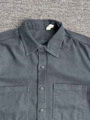 製品画像: クラシックなツイル生地の長袖ワークシャツの正面画像。100%コットン素材で作られた耐久性のあるシャツで、レトロなワークユニフォームスタイルを再現。
詳細画像: 高品質なツイル生地の長袖ワークシャツのディテール画像。細やかな縫製とコットンツイル素材の耐摩耗性が強調された画像。クラシックなワークスタイルの要素が確認できるクローズアップショット。