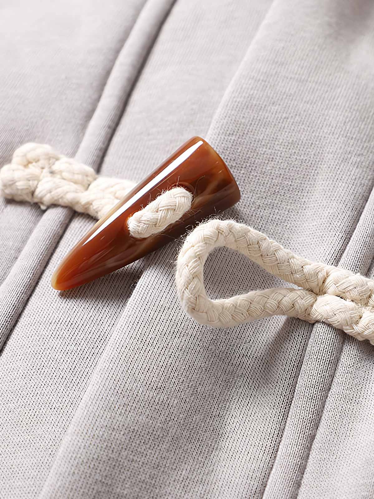 製品画像
ヴィンテージ風ホーンボタン付きフリースベストの全体正面画像。クラシックなホーンボタンデザインとカラーバリエーション(ブラック、グレー、キャメル)が特徴的です。
詳細画像
フリースベストのホーンボタンや生地のディテール画像。フリースの柔らかさとコットン混素材の耐久性を強調するクローズアップ。