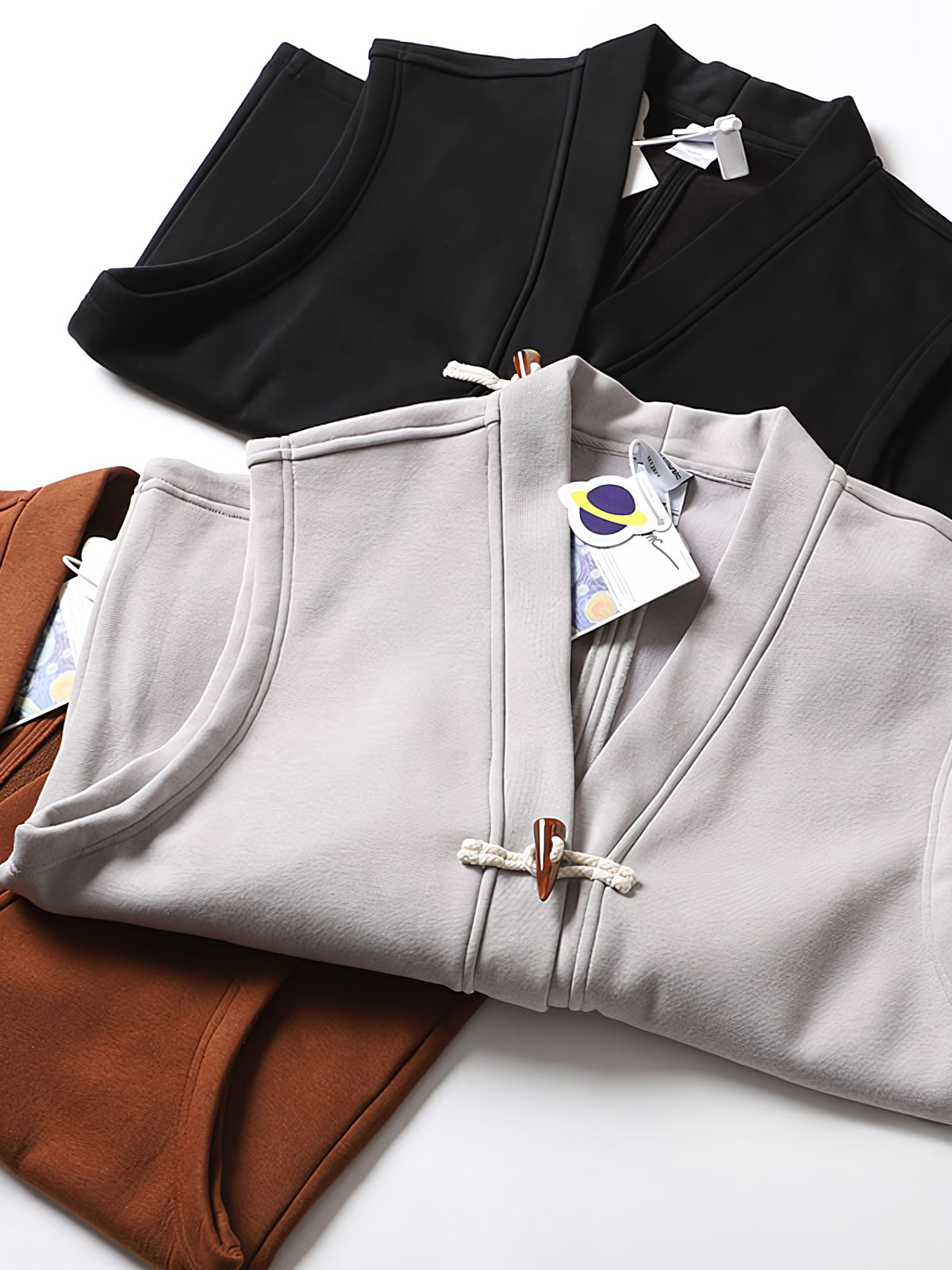 製品画像
ヴィンテージ風ホーンボタン付きフリースベストの全体正面画像。クラシックなホーンボタンデザインとカラーバリエーション(ブラック、グレー、キャメル)が特徴的です。
詳細画像
フリースベストのホーンボタンや生地のディテール画像。フリースの柔らかさとコットン混素材の耐久性を強調するクローズアップ。