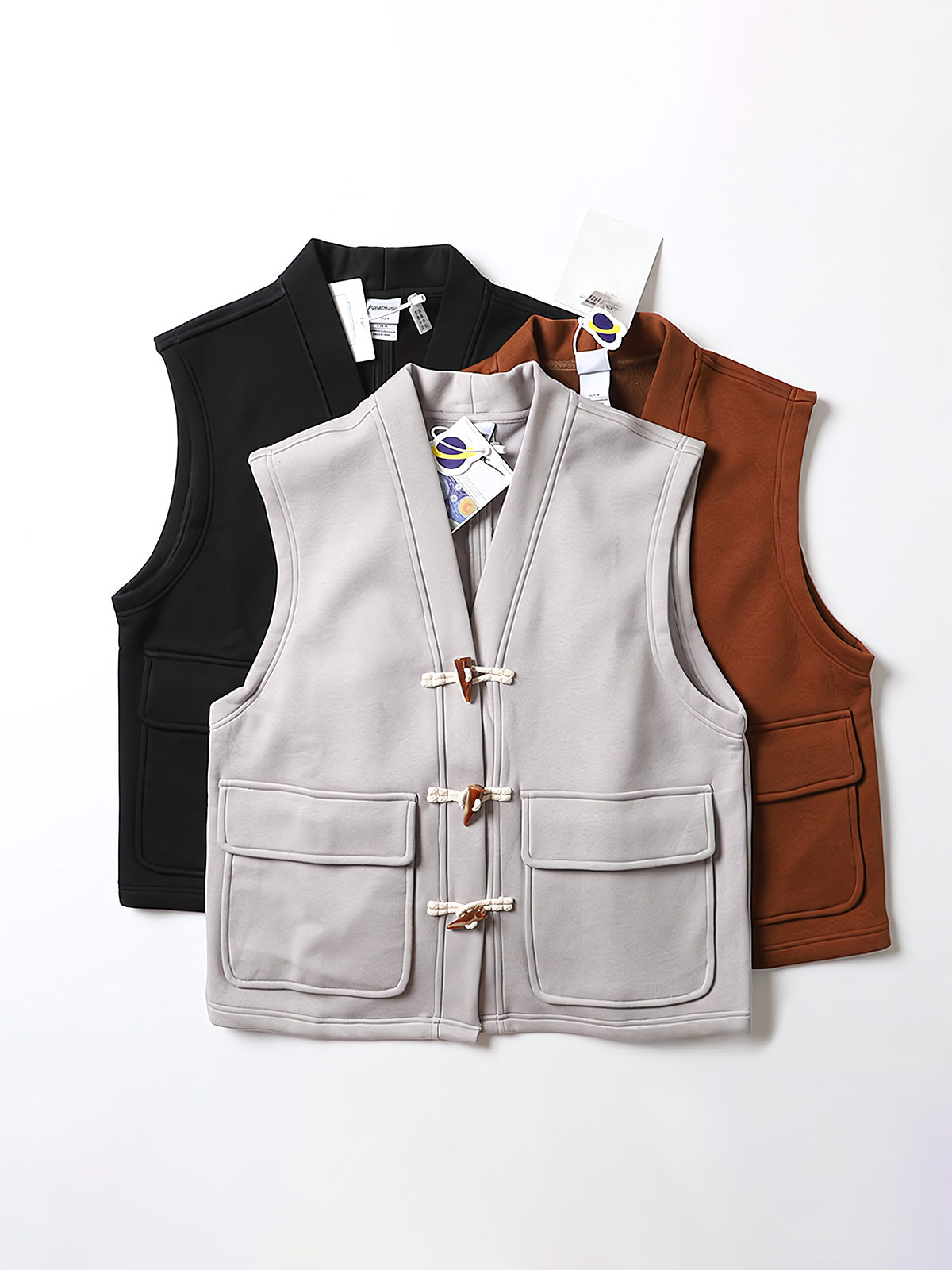 製品画像
ヴィンテージ風ホーンボタン付きフリースベストの全体正面画像。クラシックなホーンボタンデザインとカラーバリエーション(ブラック、グレー、キャメル)が特徴的です。
詳細画像
フリースベストのホーンボタンや生地のディテール画像。フリースの柔らかさとコットン混素材の耐久性を強調するクローズアップ。