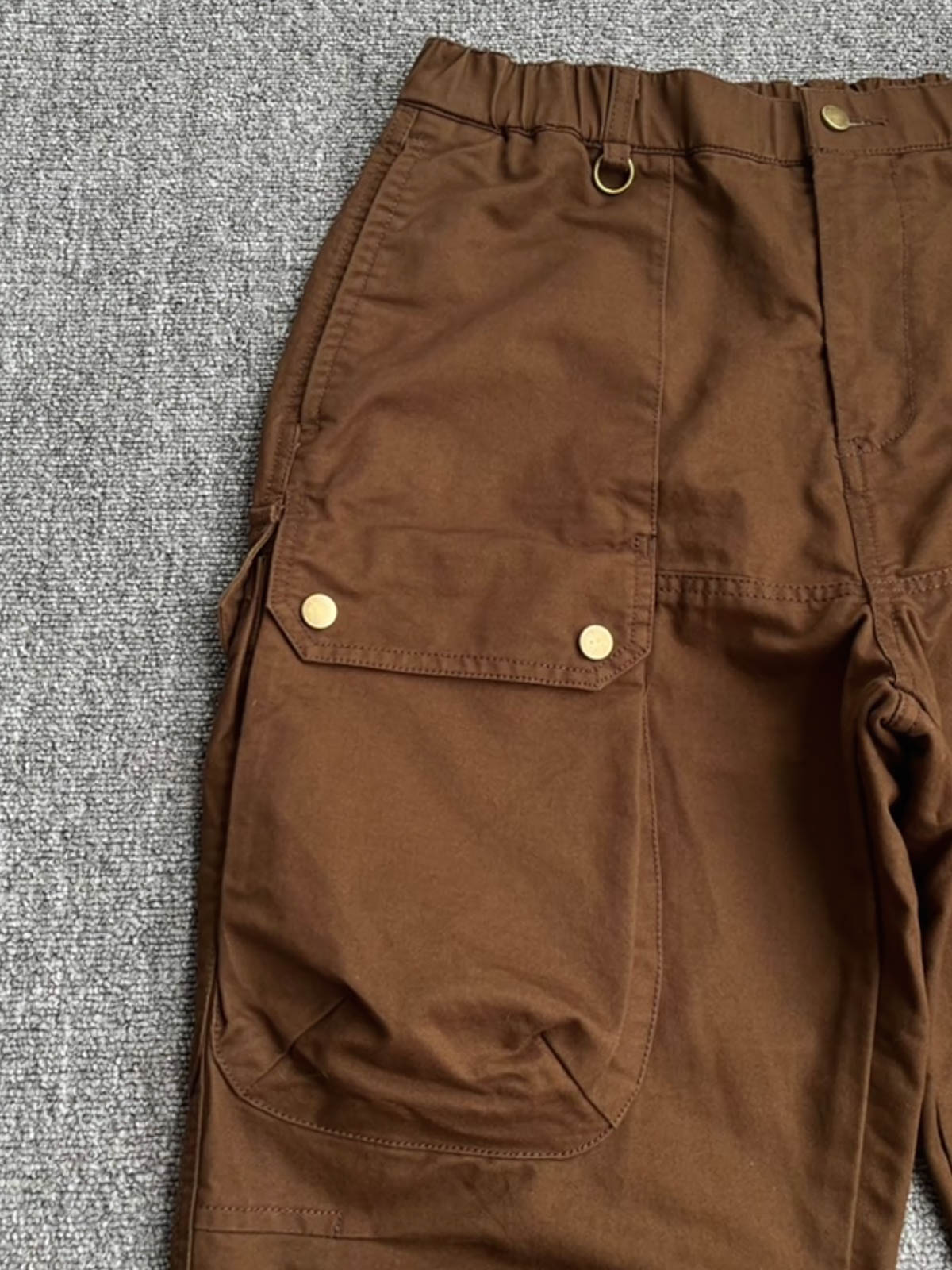 製品画像:立体裁断デザイン、多機能ポケット付きの100%コットンワークパンツの製品全体の画像
詳細画像:立体裁断ワークパンツの多機能ポケットと裾ゴム仕様ディテール部分