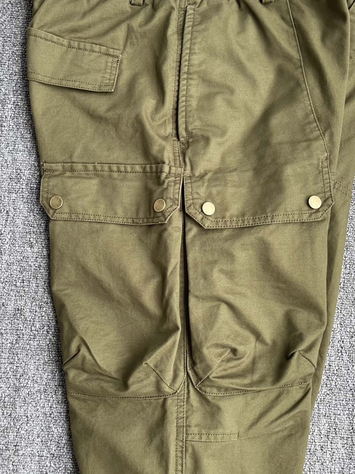 製品画像:立体裁断デザイン、多機能ポケット付きの100%コットンワークパンツの製品全体の画像
詳細画像:立体裁断ワークパンツの多機能ポケットと裾ゴム仕様ディテール部分