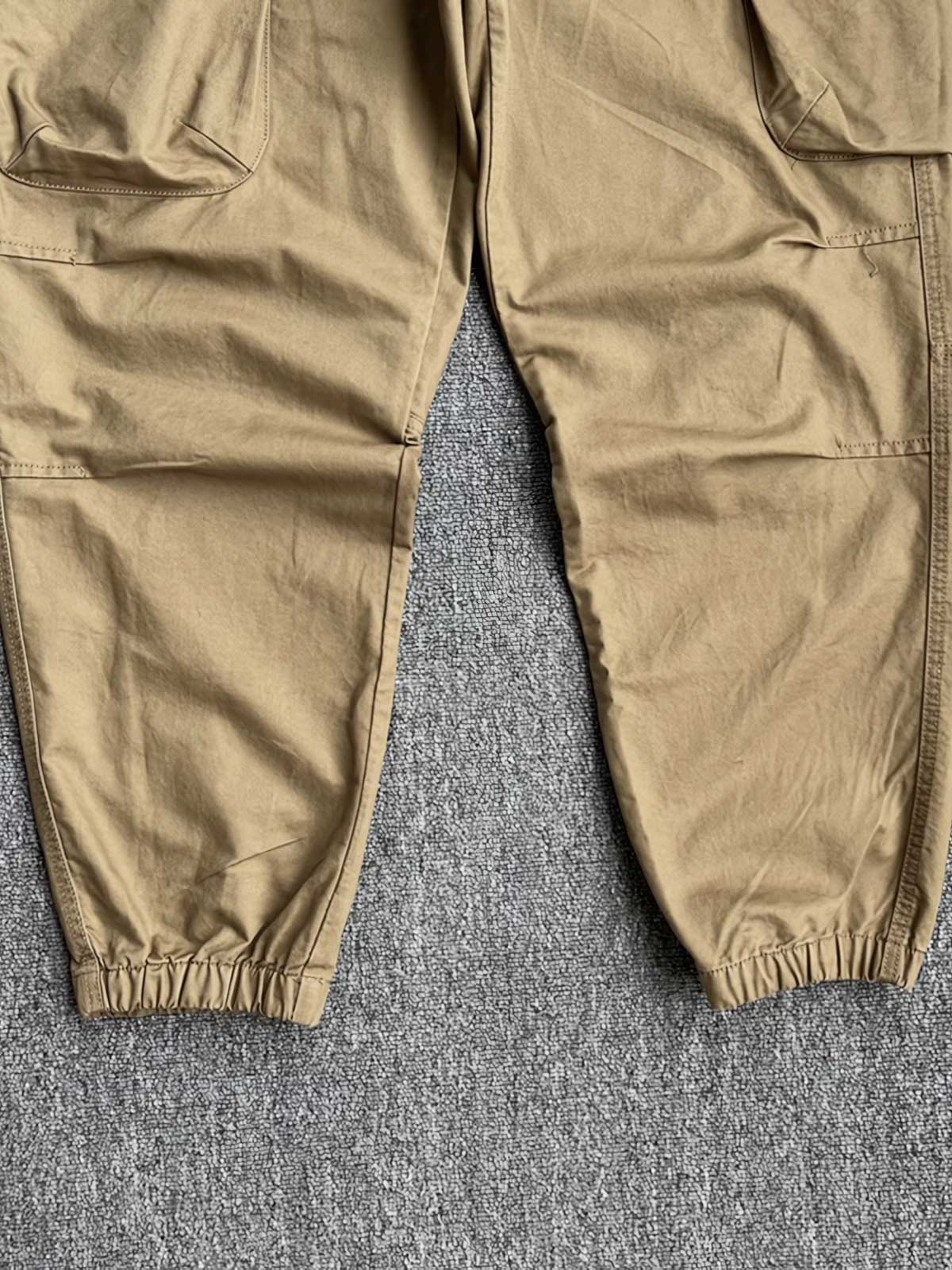 製品画像:立体裁断デザイン、多機能ポケット付きの100%コットンワークパンツの製品全体の画像
詳細画像:立体裁断ワークパンツの多機能ポケットと裾ゴム仕様ディテール部分