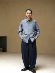 詳細画像: ツイル素材のディテールとプリーツが特徴のパンツ、シンプルなデザインで幅広いシーンに対応
モデル画像: モデルが着用する立体裁断シングルプリーツパンツ、テーパードデザインで美しいシルエットを演出