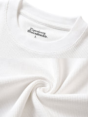 製品画像: ワッフルクルーネック カジュアルTシャツの正面ビュー
詳細画像: ワッフル生地のディテールとシルケット加工の質感を強調した特写