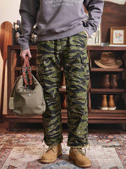 詳細画像: カーゴパンツの多機能ポケットとタイガーストライプ迷彩のディテール画像
モデル画像: タイガーストライプ迷彩カーゴパンツを着用した男性モデルの全身コーディネート