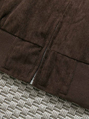 製品画像: レトロなコーデュロイジャケット平置き。シンプルな刺繍ロゴと襟付きデザインが特徴の秋冬必須アイテム
詳細画像: コーデュロイ素材の織り目と刺繍ロゴのディテール。保温性と軽量感を備えたジャケット