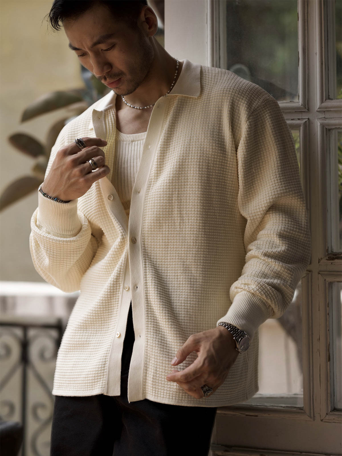 詳細画像: ワッフル編みのテクスチャとキューバシャツ風襟のディテールをクローズアップ
モデル画像: 男性モデルが着用するキューバシャツ風ニットシャツ - 全体スタイルと着こなし例