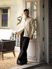 詳細画像: ワッフル編みのテクスチャとキューバシャツ風襟のディテールをクローズアップ
モデル画像: 男性モデルが着用するキューバシャツ風ニットシャツ - 全体スタイルと着こなし例