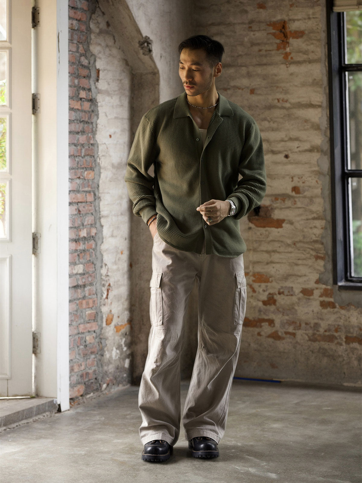 詳細画像: ワッフル編みのテクスチャとキューバシャツ風襟のディテールをクローズアップ
モデル画像: 男性モデルが着用するキューバシャツ風ニットシャツ - 全体スタイルと着こなし例