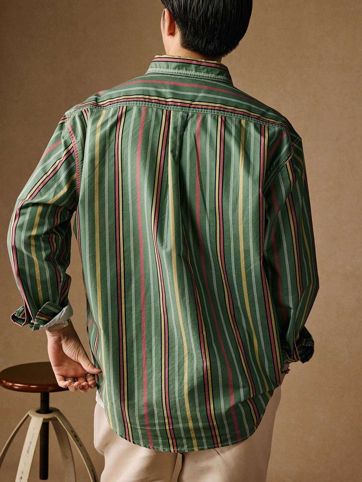 詳細画像: ストーンウォッシュ加工でヴィンテージ感を表現したストライプデザイン、柔らかな質感と風合いを強調
モデル画像: モデルがグリーンストライプシャツを着用し、ヴィンテージ感あふれるリラックススタイルを演出