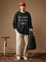 詳細画像: 透かし刺繍ロゴとナチュラルロールドヘムのディテール特写、細部の精巧さを強調
モデル画像: モデル着用のマスタードイエローの透かしロゴ刺繍セーター、ヴィンテージカジュアルなコーディネート例