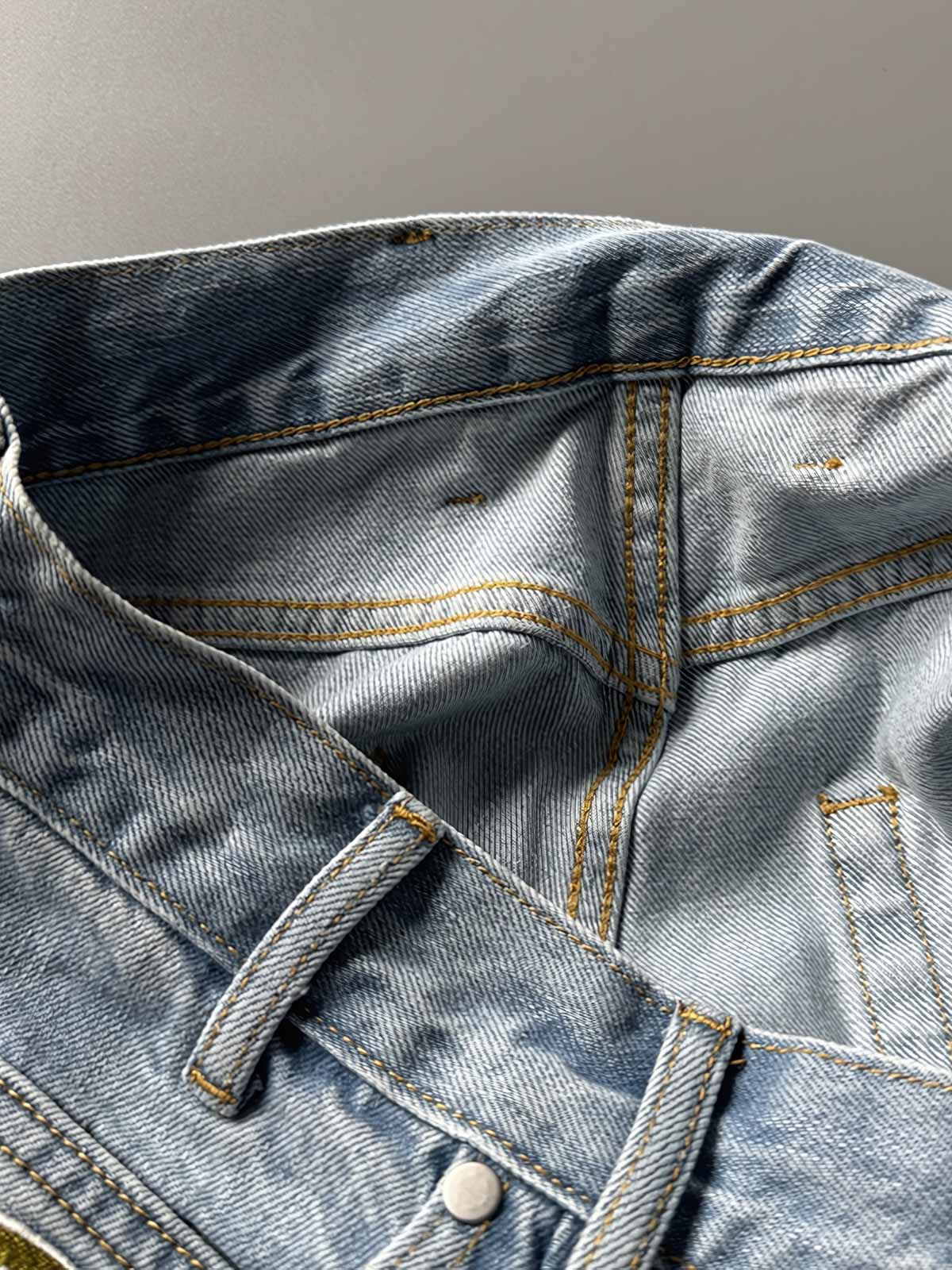 製品画像: 刺繍デザインが特徴のテーパードシルエットデニムパンツ全体画像
詳細画像: ポケット部分の刺繍ディテールとクラシックデニムブルーの生地