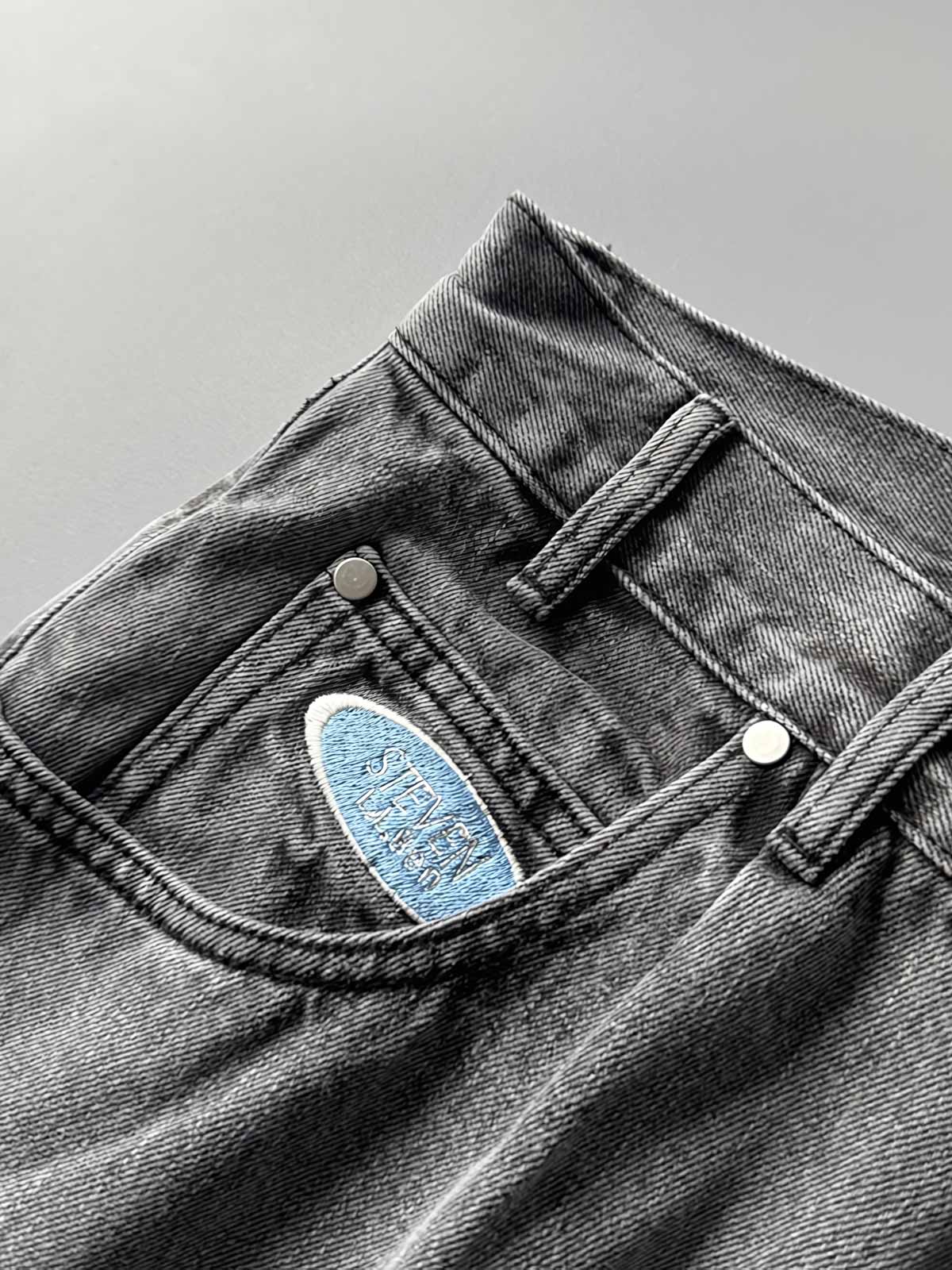 製品画像: 刺繍デザインが特徴のテーパードシルエットデニムパンツ全体画像
詳細画像: ポケット部分の刺繍ディテールとクラシックデニムブルーの生地