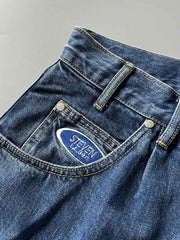 製品画像: 刺繍デザインが特徴のテーパードシルエットデニムパンツ全体画像
詳細画像: ポケット部分の刺繍ディテールとクラシックデニムブルーの生地