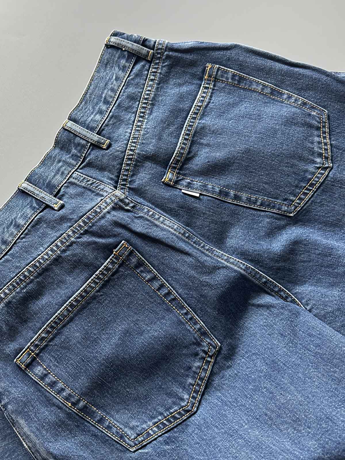 製品画像: 刺繍デザインが特徴のテーパードシルエットデニムパンツ全体画像
詳細画像: ポケット部分の刺繍ディテールとクラシックデニムブルーの生地