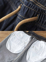 製品画像: リラックスシルエットのテーパードジョガーデニムパンツの全体ビュー
詳細画像: ウエスト部分のドローコードと裾リブデザインのディテール