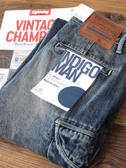 製品画像: レトロウォッシュ加工のヘビーウェイトデニムワークパンツのフロントビュー
詳細画像: サイドポケットとレザー調整バックルのディテール特写