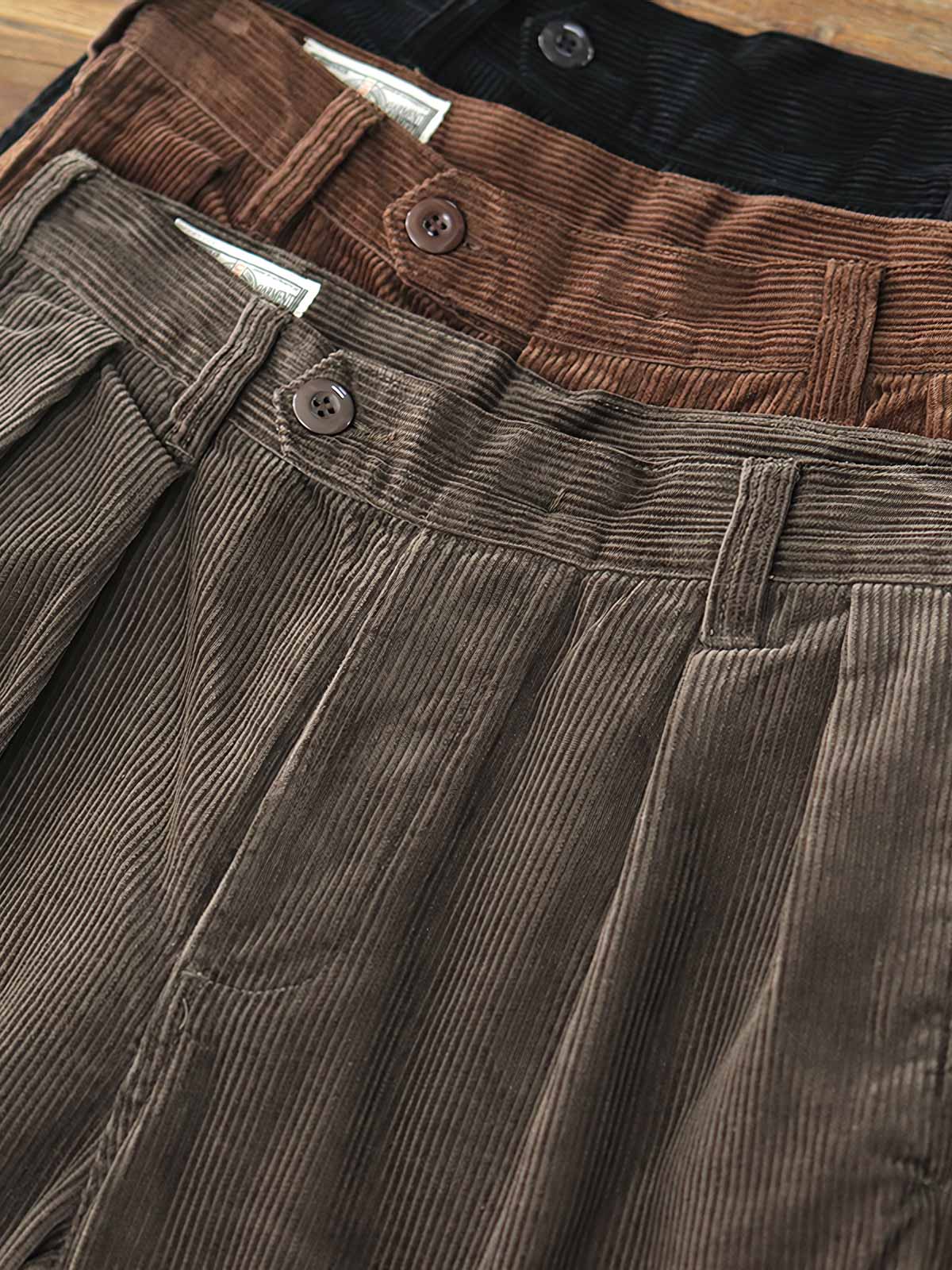 製品画像: "ヴィンテージコーデュロイパンツの正面ビュー、ウォッシュ加工で独特の風合いを持つデザイン"
詳細画像: "コーデュロイの割経起毛とウエストの風紀ボタンデザインの詳細、ヴィンテージ感を演出"