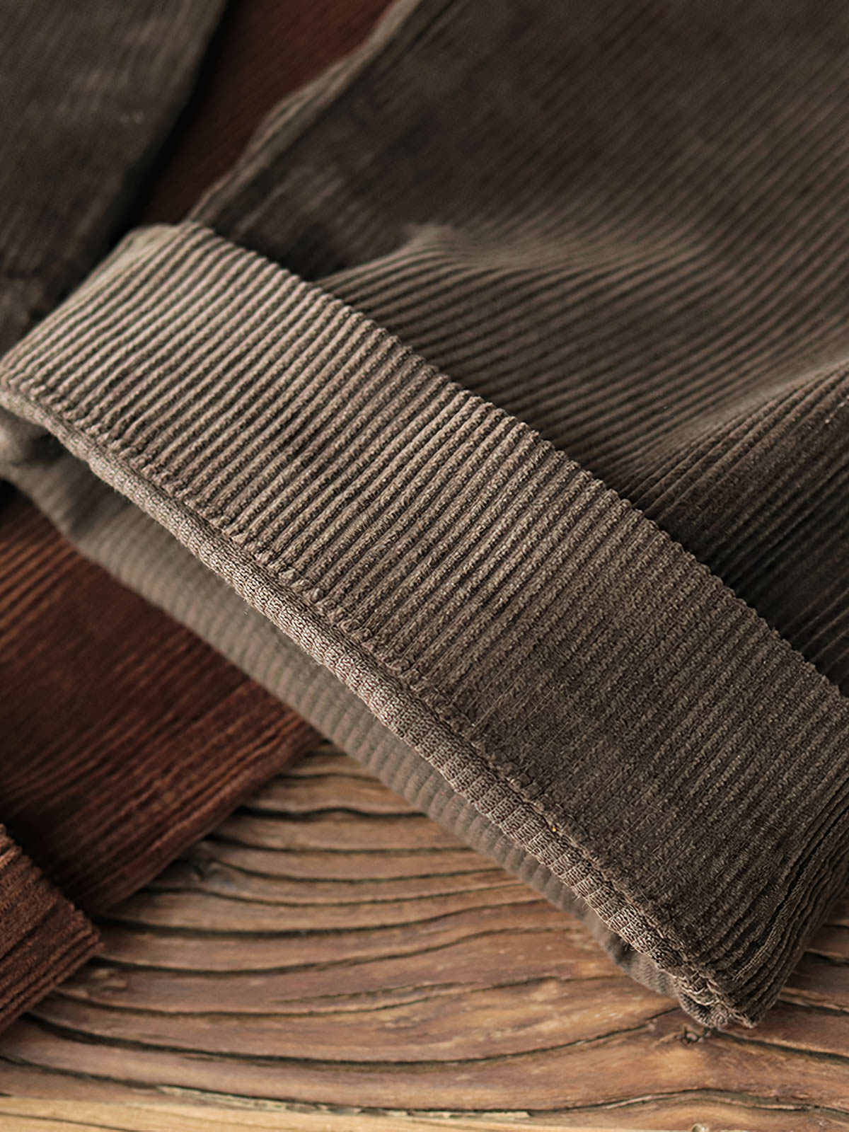 製品画像: "ヴィンテージコーデュロイパンツの正面ビュー、ウォッシュ加工で独特の風合いを持つデザイン"
詳細画像: "コーデュロイの割経起毛とウエストの風紀ボタンデザインの詳細、ヴィンテージ感を演出"