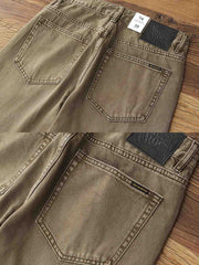 製品画像:アメカジ風泥染めストレートデニムパンツの正面展示。低彩度のブラウンカラーがヴィンテージ感を演出。
詳細画像:カスタムボタンとウォッシュ加工のディテールをクローズアップ。レザーパッチがデザインのアクセントに。